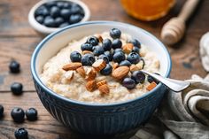 a bowl of oatmeal with blueberries and almonds on the side