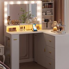 a white vanity with lights on it and a laptop in front of the mirror that is lit up