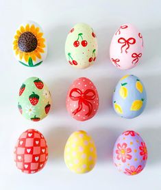 an assortment of painted eggs on a white surface