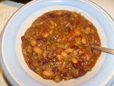 a bowl filled with beans and meat on top of a table