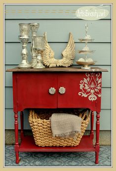 a red table with baskets on it and an angel figurine sitting on top