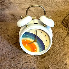 an alarm clock sitting on top of a furry surface with the colors of rainbow painted on it