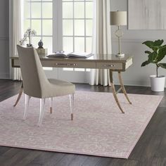 a room with a desk, chair and rug on the floor in front of windows