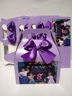 an open box with purple ribbon and two spoons in it