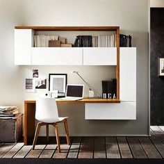 a white desk and chair in front of a book shelf with books on top of it