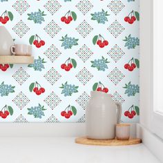 the wallpaper is decorated with cherries and blue flowers on it, as well as two mugs