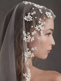 a woman wearing a veil with flowers on it