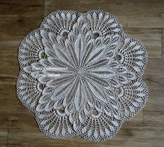 a white doily sitting on top of a wooden floor