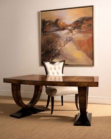 a painting hangs on the wall above a table with two chairs and a bench in front of it