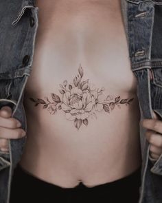 a woman's stomach with a flower tattoo on her belly and the bottom part of her body