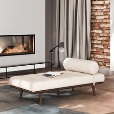 a living room with a couch, coffee table and fire place in front of a brick wall