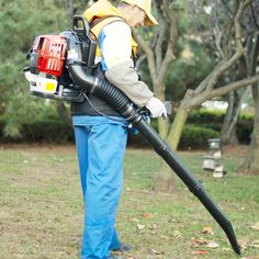 a man in blue pants holding a large black vacuum on top of his back legs