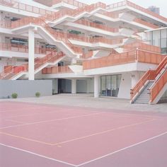 an empty tennis court with stairs and balconies