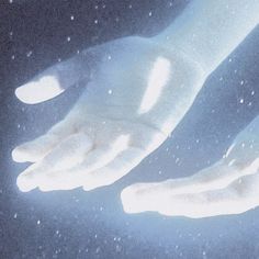 two white hands reaching towards each other with snow falling down on the ground behind them