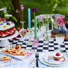 a table topped with cakes and desserts on top of a checkered table cloth