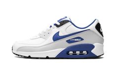 The Nike Air Max 90 Leather “White/Game Royal” is a sporty-looking colorway of the retro performance running and lifestyle shoe.  The Air Max 90 was designed by Tinker Hatfield and released by Nike in 1990, and today stands as one of the most iconic Nike running shoes ever.  On this “White/Game Royal” colorway, the shoe features a white leather base and a Photon Dust tumbled leather mudguard.  White leather is seen on the overlay on the mid-panel while a Game Royal leather Swoosh is located on either side of the sneaker.  Additional Game Royal detailing is found on the “Air Max” branding window on the lateral side of the heel.  Classic “Nike Air” detailing appears on the heel and “Nike Air Max” branding is found on the royal blue tongue tag.  A Game Royal panel surrounds the visible Air un Nike Air Max 90 Outfit Men, Nike Air Max 90 Outfit, Royal Shoes, Nike Air Max 90 White, Nike X Travis Scott, Nike Fashion Sneakers, Air Max 90 Leather, Classic Nike, Tinker Hatfield