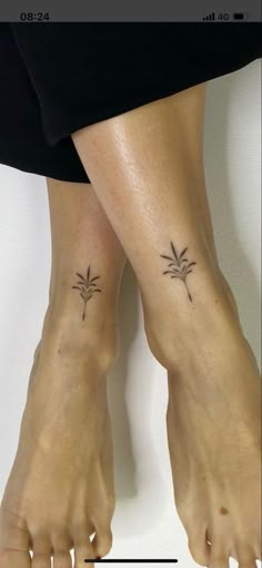 two small tattoos on the legs of someone's feet, one is palm trees