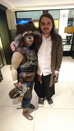 a man standing next to a person dressed as rocket raccoon in a store