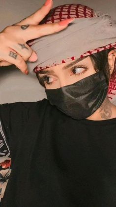 a woman wearing a bandana and covering her face with a mask on top of her head