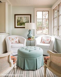 a living room filled with white furniture and lots of window sill space next to a painting on the wall