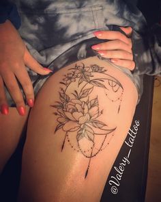 a woman's thigh with a flower tattoo on it