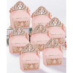 there are many pink boxes with gold designs on the top and one has a crown on it