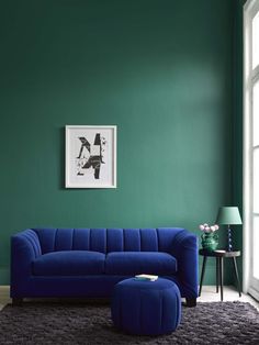 a living room with green walls and a blue couch