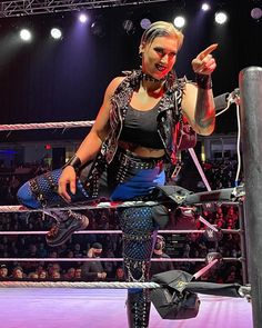 a woman standing on top of a wrestling ring