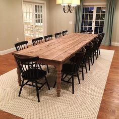 a large wooden table sitting on top of a white rug