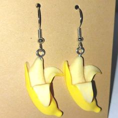 two pieces of fruit that are shaped like banana peels hanging from earwires