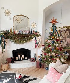 a living room decorated for christmas with a fireplace and tree in the corner, surrounded by holiday decorations