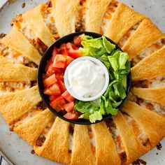 an appetizer dish with tortilla shells, lettuce and tomatoes