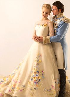 a man and woman are dressed in wedding gowns, posing for a photo with their arms around each other