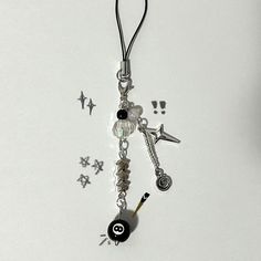 a keychain with charms attached to it on a white surface and stars around it