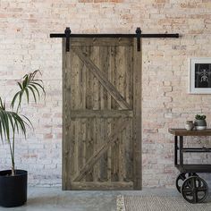 an open wooden door in front of a brick wall next to a potted plant