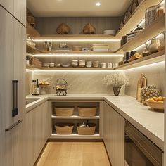 a kitchen filled with lots of counter top space next to a wooden floor and white walls