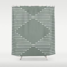 a green shower curtain with white lines and dots on the bottom, in front of a gray background