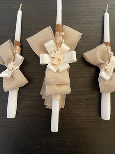 three candles with bows on them sitting on a table