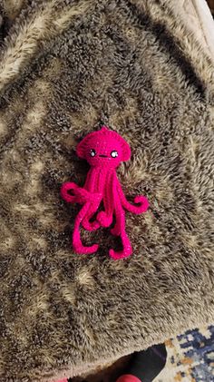 a pink stuffed animal sitting on top of a bed