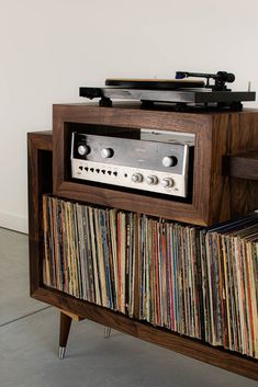 an old record player is sitting on top of a shelf with records and tape recorders