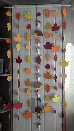 the fall leaves are hanging from the curtain in the room, and it looks like they have been made out of paper