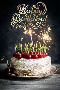 a birthday cake with sparklers and cherries on it