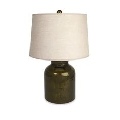 a green table lamp with a white shade on the base and a light bulb in front of it