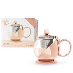 a pink coffee pot next to a box