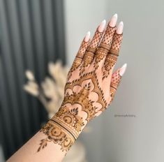 a woman's hand with henna tattoos on it