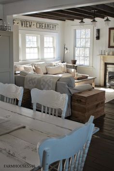 a living room filled with white furniture and lots of pillows on top of it's couches