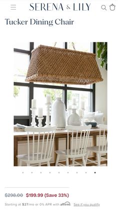 a white dining room table with chairs and a basket hanging over it's head