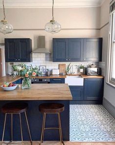 a kitchen with two stools at the counter and an island in front of it