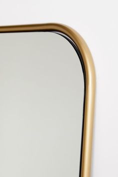 the reflection of a gold framed mirror against a white wall