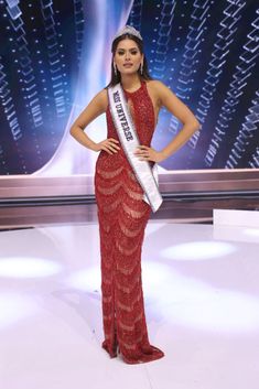 a woman in a red dress posing for the camera with her hands on her hips